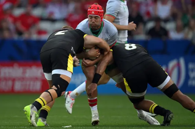 Double hit: Rafael Simoes is tackled by Taulupe Faletau and Dewi Lake