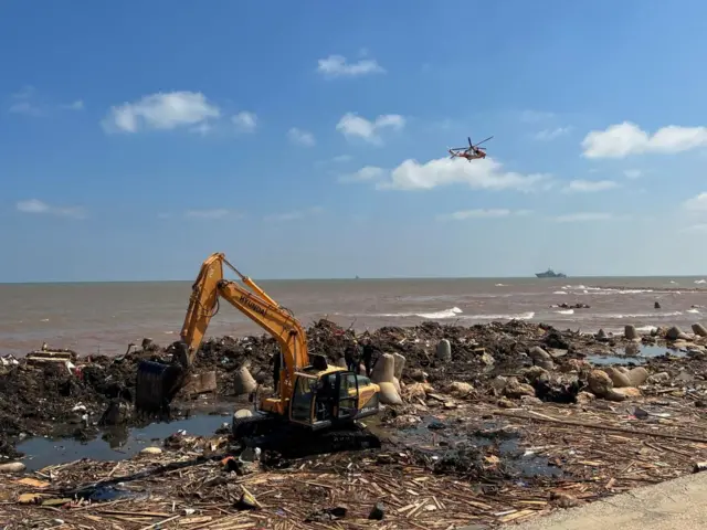 A digger and helicopter near the sea front in Derna