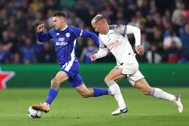 Cardiff City midfielder Aaron Ramsey is chased by Swansea City's Jay Fulton