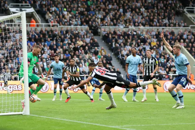 Bruno Guimaraes of Newcastle United has a shot saved by Mark Flekken of Brentford