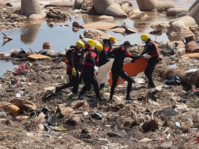 Rescuers in wetsuits searching for bodies