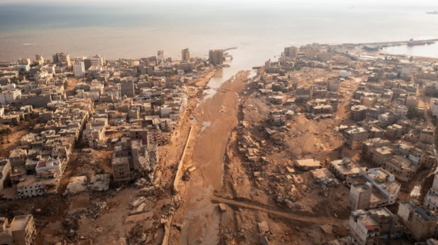 An aerial view of the huge channel has been carved out of the earth where the river once flowed through Derna and into the sea, with damaged and destroyed buildings visible on either side