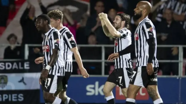 Notts County players celebrate a goal against Salford