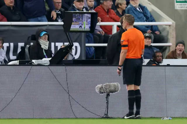 Match Referee Craig Pawson checks the VAR screen