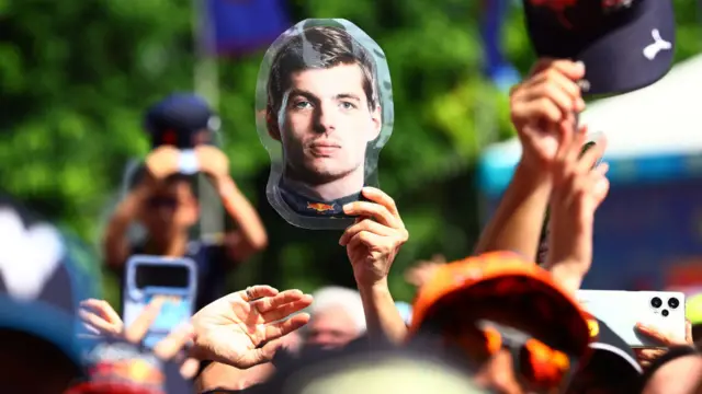 Fans hols up a Max Verstappen head