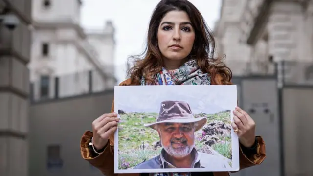 Roxanne Tahbaz holds a photograph of her father, Morad Tahbaz, outside the Foreign, Commonwealth and Development Office on April 13, 2022 in London, England