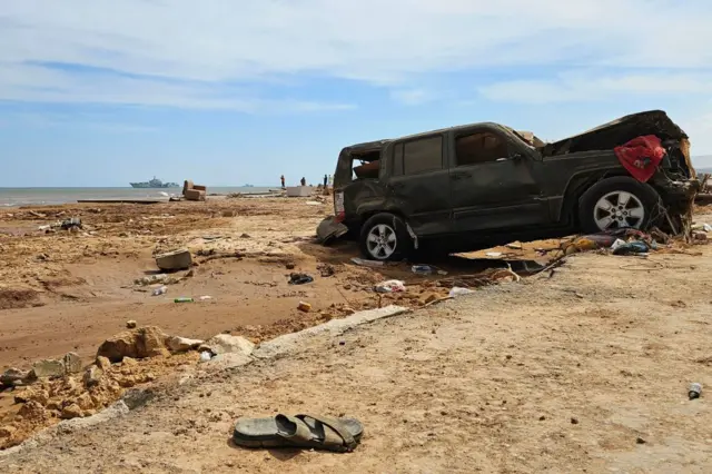 A destroyed vehicle is washed ashore in Libya's eastern port city of Derna on September 17, 2023, following deadly flash floods.