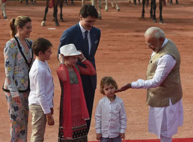 India's Prime Minister Narendra Modi (R) touches the cheek of Hadrien Trudeau (2nd R), the youngest son of Canada's Prime Minister Justin Trudeau (4th L) and his wife Sophie Gregoire Trudeau (L), as their other children Ella-Grace (3rd L) and Xavier (2nd L) look on, while attending a ceremonial reception at the Presidential Palace in New Delhi on 23 February 2018