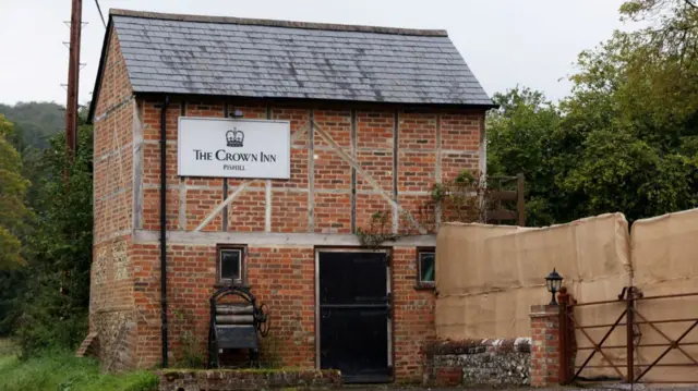 The Crown Inn pub owned by British comedian and actor Russell Brand's company is surrounded by a temporary screen in Oxfordshire