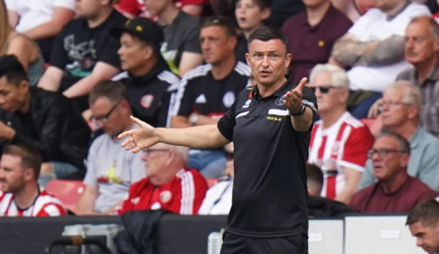 Paul Heckingbottom with his arms up in the air on the touchline