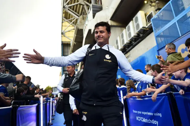 Pochettino arrives at Stamford bridge and high fives fans along the walk way.