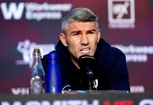 Liam Smith sits in front of a microphone