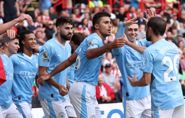 Man City players celebrate their late winner at Bramhall Lane.