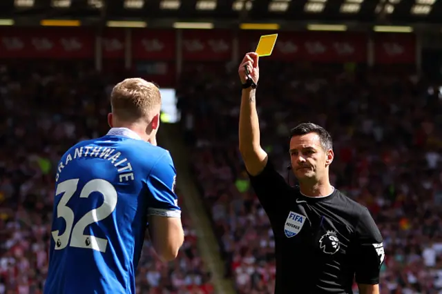 Referee Andy Madley shows Branthwaite a yellow card