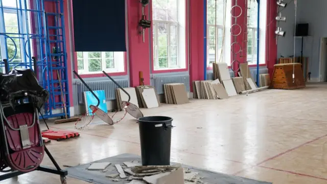 Parts of a damaged ceiling lie in the middle of the school hall a Parks Primary