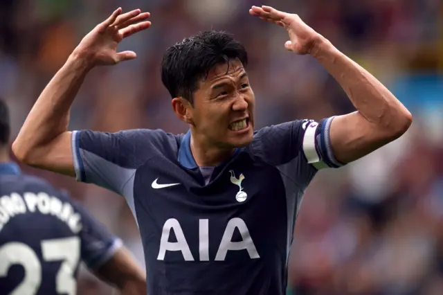 Song Heung-min pumps his arms up and down and smiles at the fans.