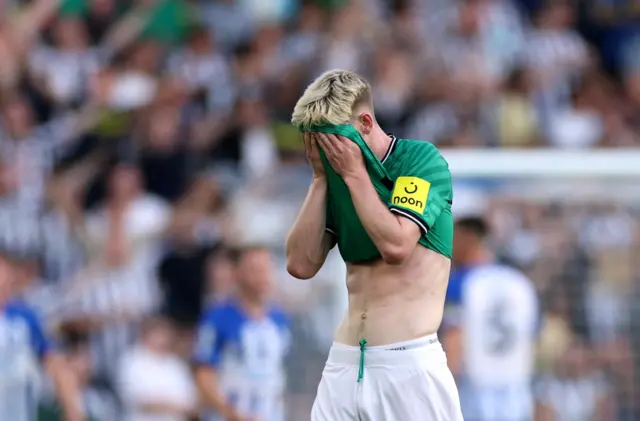 Anthony Gordon covers his face with his shirt in frustration.