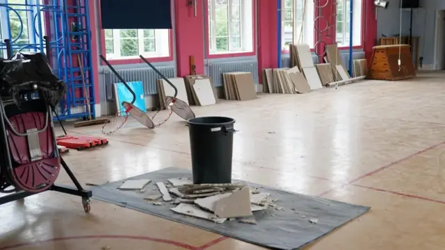 Parts of a fallen RAAC wall lie in the middle of a school hall