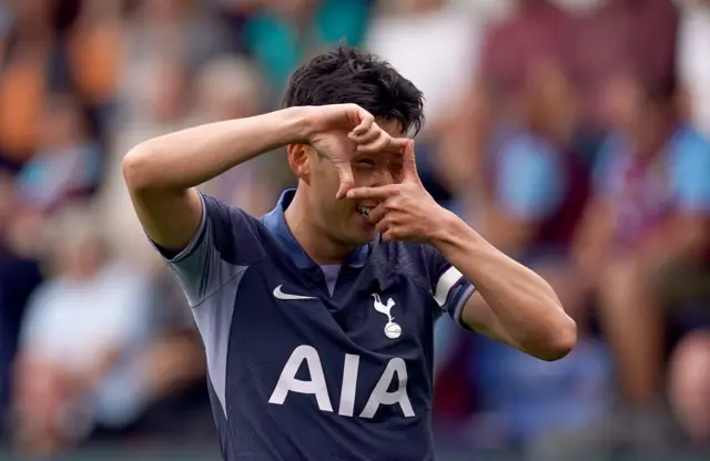 Son does his signature celebration of a photo frame in front of his eye,