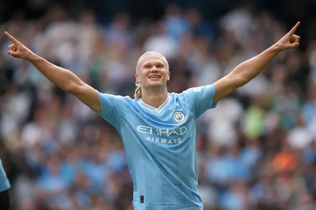 Haaland with his arms aloft celebrating