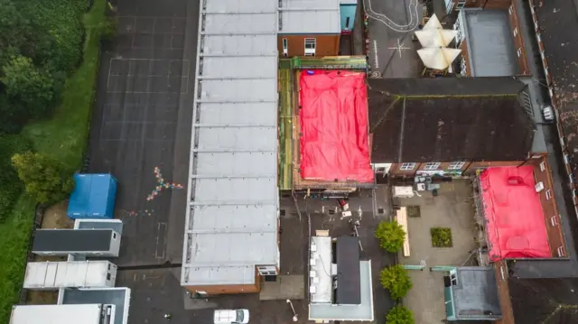 Rooves are covered with plastic sheets while work to replace the RAAC components