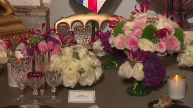 Bouquets of flowers, glasses, and candles cover a table