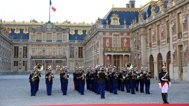 Guards are stations at the red carpet outside Versailles