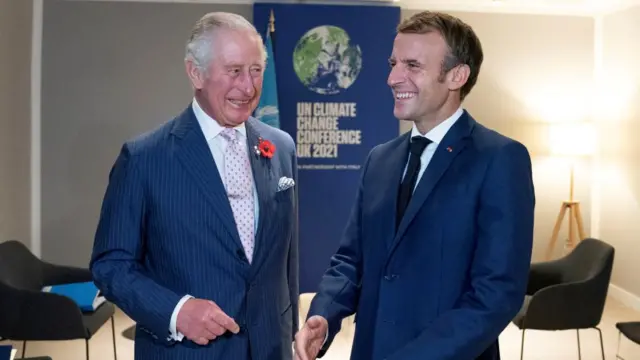 Then Prince Charles and French President Emmanuel Macron smiling together at a UN Climate event in 2021