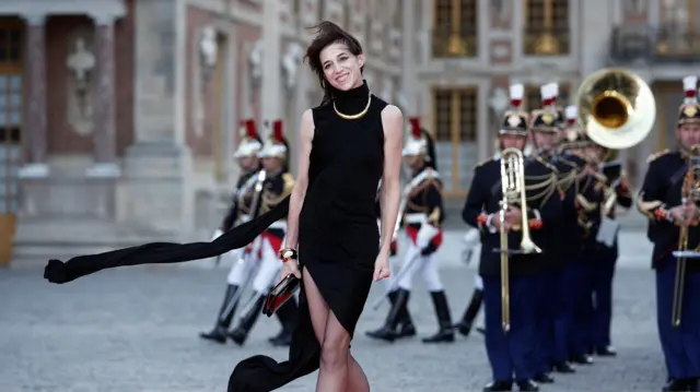 Charlotte Gainsbourg smiling with band playing behind her