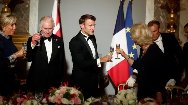 Emmanuel Macron toasts Camilla with King Charles raises glass in background