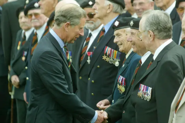 Charles speaks with British WW2 veterans during a ceremony in Normandy, June 2004