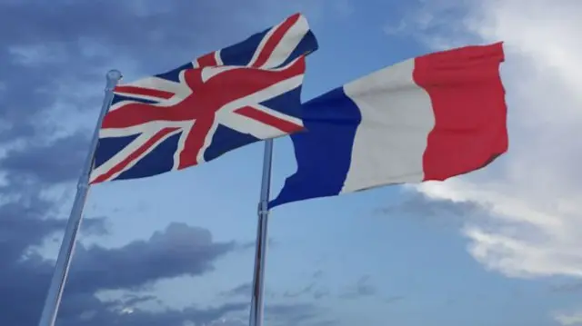 A Union Jack flies next to the flag of France