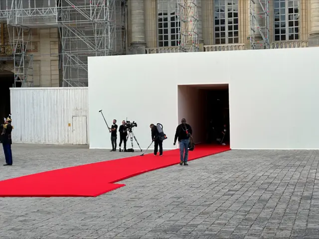 Last minute vacuuming of the red carpet at Versailles