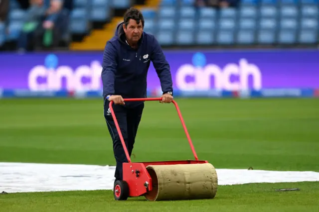 A meber of the Headingley groundstaff mops up water