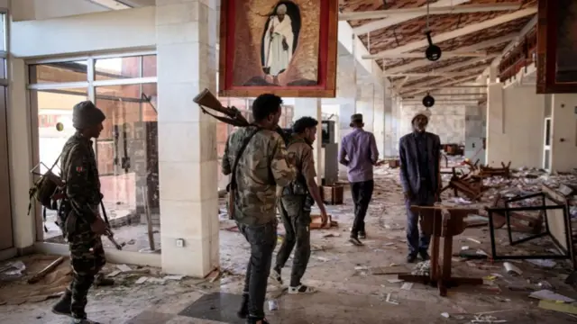 Amhara Fano militia fighters walk in the ransacked terminal at the Lalibela airport in Lalibela, on December 7, 2021