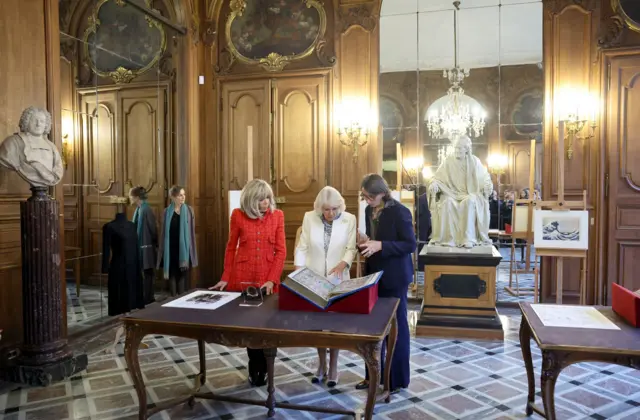 Brigitte Macron (left) and Queen Camilla (centre) with President of the French National Library, Laurence Engel (right)