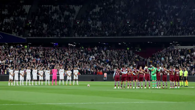 Players observe a moments silence ahead of kick off at London Stadium.