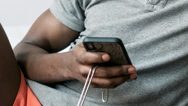 A man looks at a gay dating app on his phone - stock photo