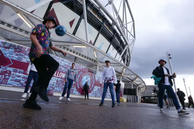 West Ham fans play keepy ups outside the ground before the game.