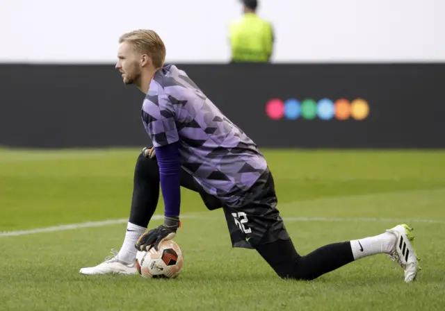 Kelleher begins to warm up for Liverpool knelt on the floor with the ball under his hand.