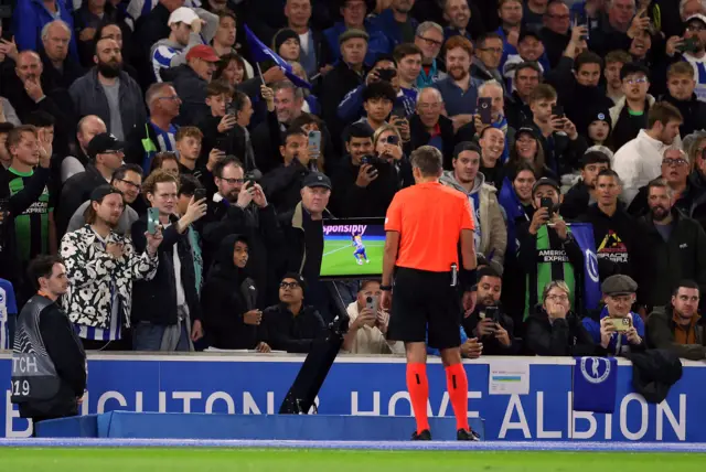 Referee Kristo Tohver looks at the VAR screen.