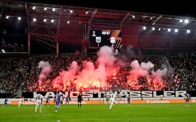 LASK fans show their support by lighting red flares in the crowd.