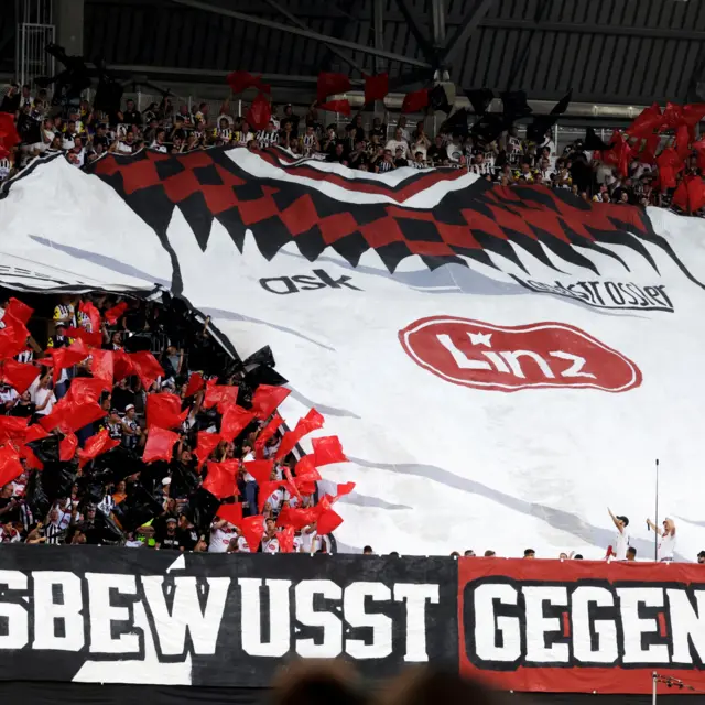 LASK fans unveil a tifo of a home shirt ahead of kick off.