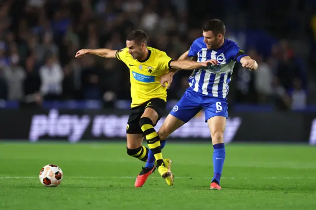 James Milner attempts to win the ball back for Brighton in the midfield.