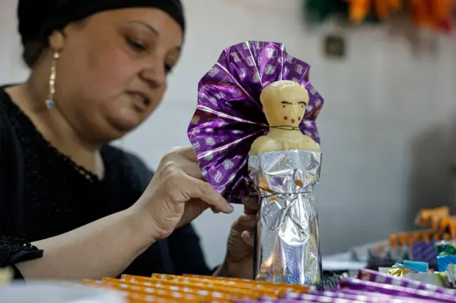 A woman decorates a statuette made of sugar in Cairo, Egypt - 21 September 2023