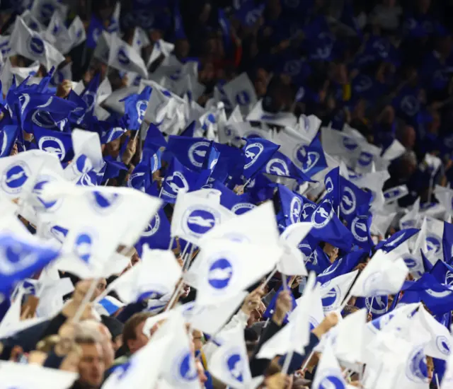 Brighton fans wave blue and white flags to build atmosphere before kick off.