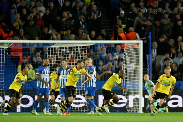 Sidibe begins to run away in celebration as his teammates look to follow suit.