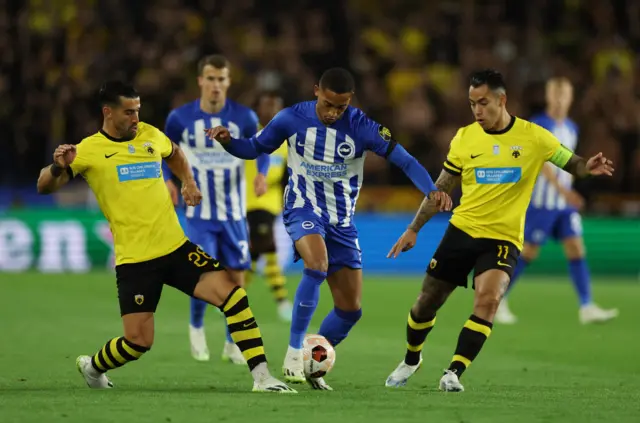 Joao Pedro is swamped by AEK defenders.