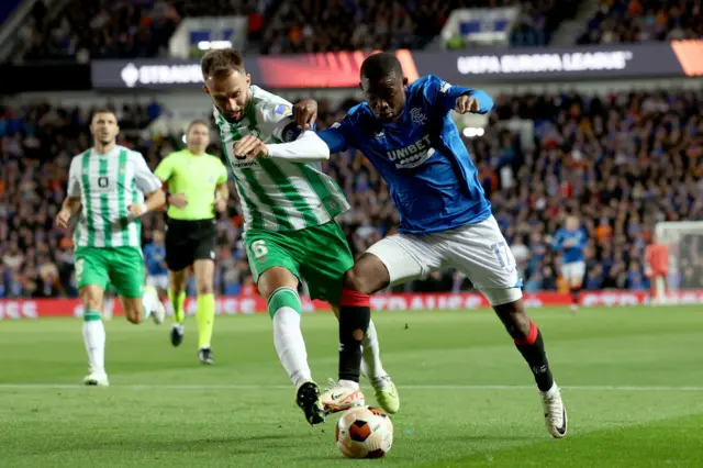 Matondo and Pezzella battle for the ball on the wing at Ibrox.