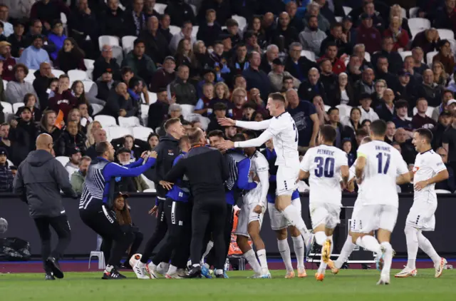 Stanic is mobbed by teammates as they celebrate a shock lead v West Ham.